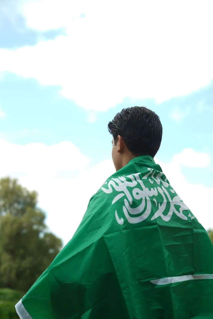 طالب يحمل العلم السعودي
